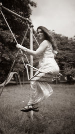 Side view of woman holding rope on field