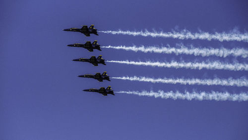 Low angle view of airshow against sky