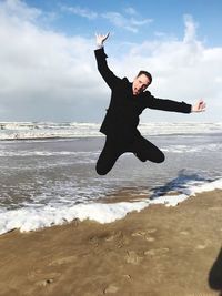Man jumping on shore at beach