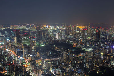 High angle view of illuminated cityscape against sky at night