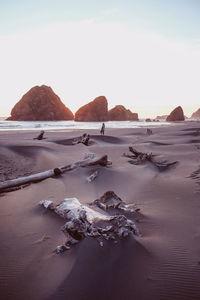 Woman standing at beach against clear sky