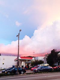 Cars on road against cloudy sky