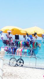 Bicycles on beach against clear blue sky