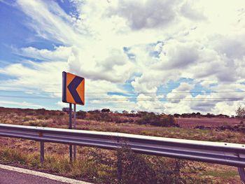Road sign against sky