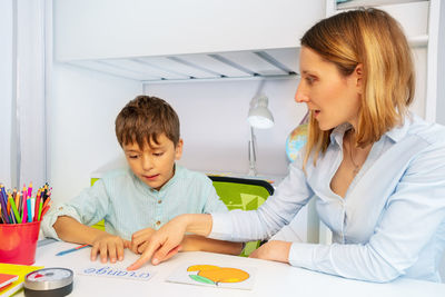 Psychologist teaching boy at home