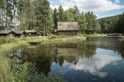 Reflection of historical wooden cabins against blue sky