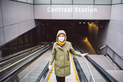 Portrait of woman standing on escalator at subway station