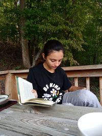 Teen reading on dock