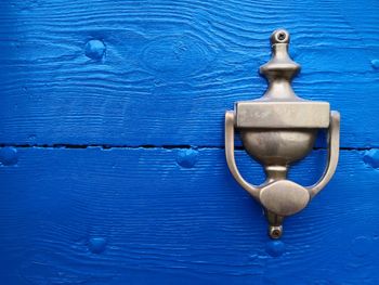 Close-up of knocker on blue door