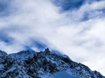 Low angle view of snowcapped mountains against sky