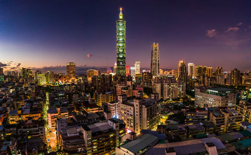 Aerial view of illuminated buildings against sky at night