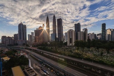 View of buildings in city against cloudy sky