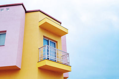 Low angle view of yellow building against sky
