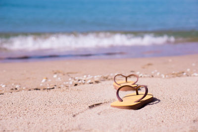 Close-up of heart shape on sand at beach