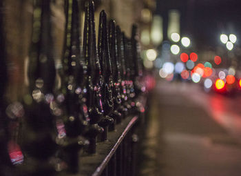 Illuminated wet street in city at night