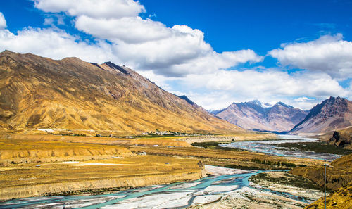 Scenic view of lake by mountains against sky