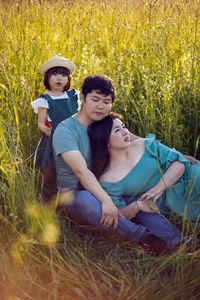 Korean family mom and father with a girl child daughter with candy lying on a green field in summer
