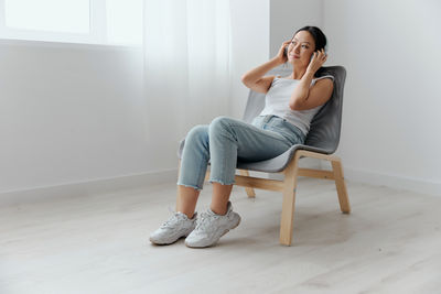 Young woman sitting on floor at home