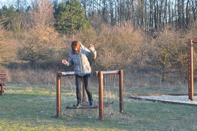 Woman standing on jungle gym at playground