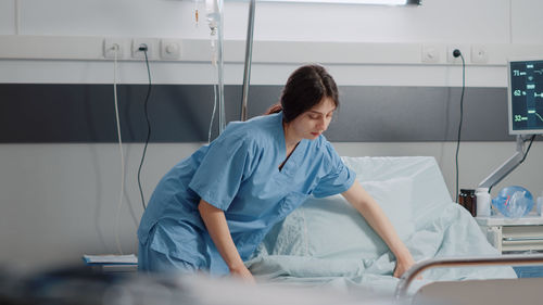 Nurse arranging hospital bed