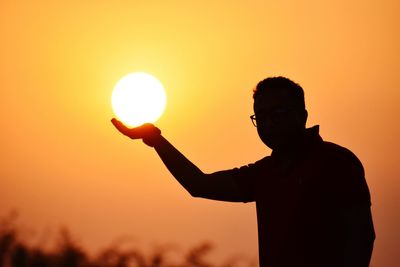 Silhouette man against orange sky during sunset