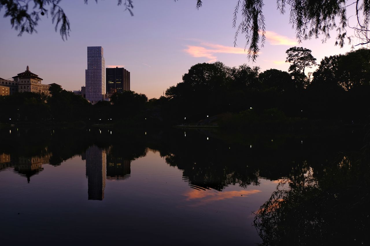 reflection, water, sky, architecture, tree, building exterior, built structure, waterfront, lake, nature, building, sunset, plant, no people, city, silhouette, tranquility, symmetry, outdoors, office building exterior, skyscraper, reflection lake