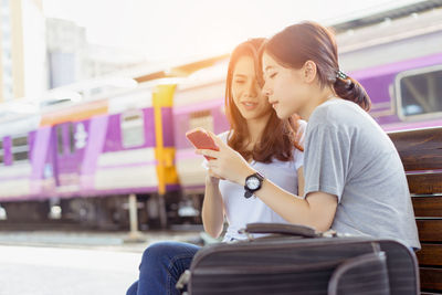 Young woman using mobile phone while sitting in bus