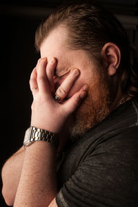 Close-up portrait of a young man over black background