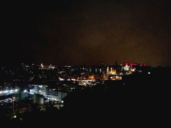 Illuminated cityscape against sky at night