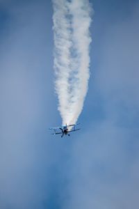 Low angle view of airplane flying in blue sky