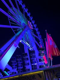 Low angle view of illuminated ferris wheel at night