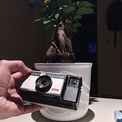 Close-up of hand holding camera on table