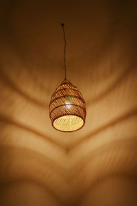 Low angle view of illuminated pendant light hanging from ceiling