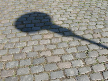 High angle view of street light shadow on cobbled street