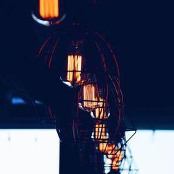 Low angle view of illuminated electric lamp against sky