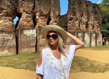 Portrait of young woman wearing sunglasses standing outdoors