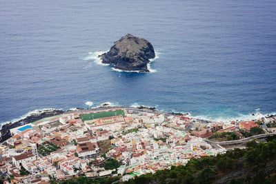 High angle view of town by sea against sky