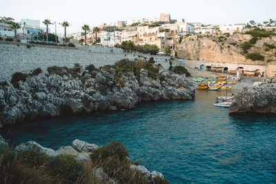 Buildings by sea against sky