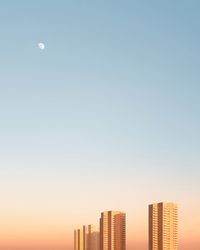 Modern buildings against sky at dusk