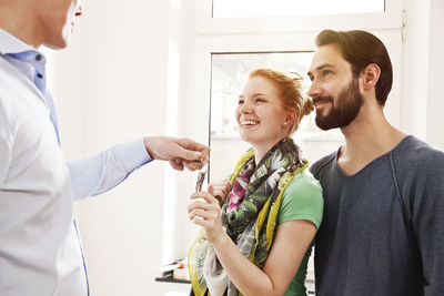 Young couple receiving house key from real estate agent