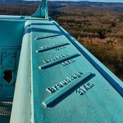 Close-up of information sign against blue sky