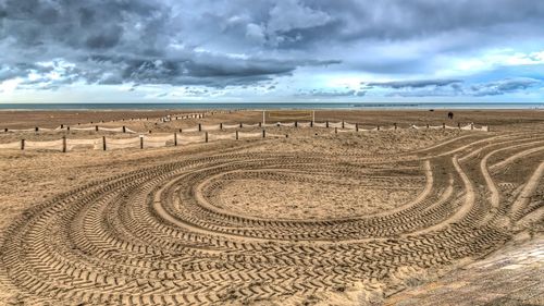 Scenic view of beach against cloudy sky