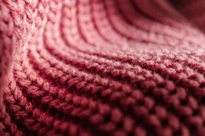 Knitted texture of a pink sweater or scarf close-up.