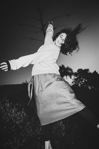 Midsection of woman standing on field against sky