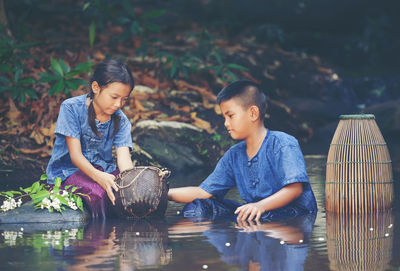 Children playing in river at forest