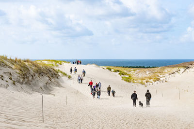 People at beach against sky