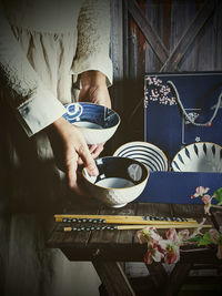 A chef is holding a set of japanese bowl in dark photography