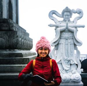 Portrait of a woman with statue as background