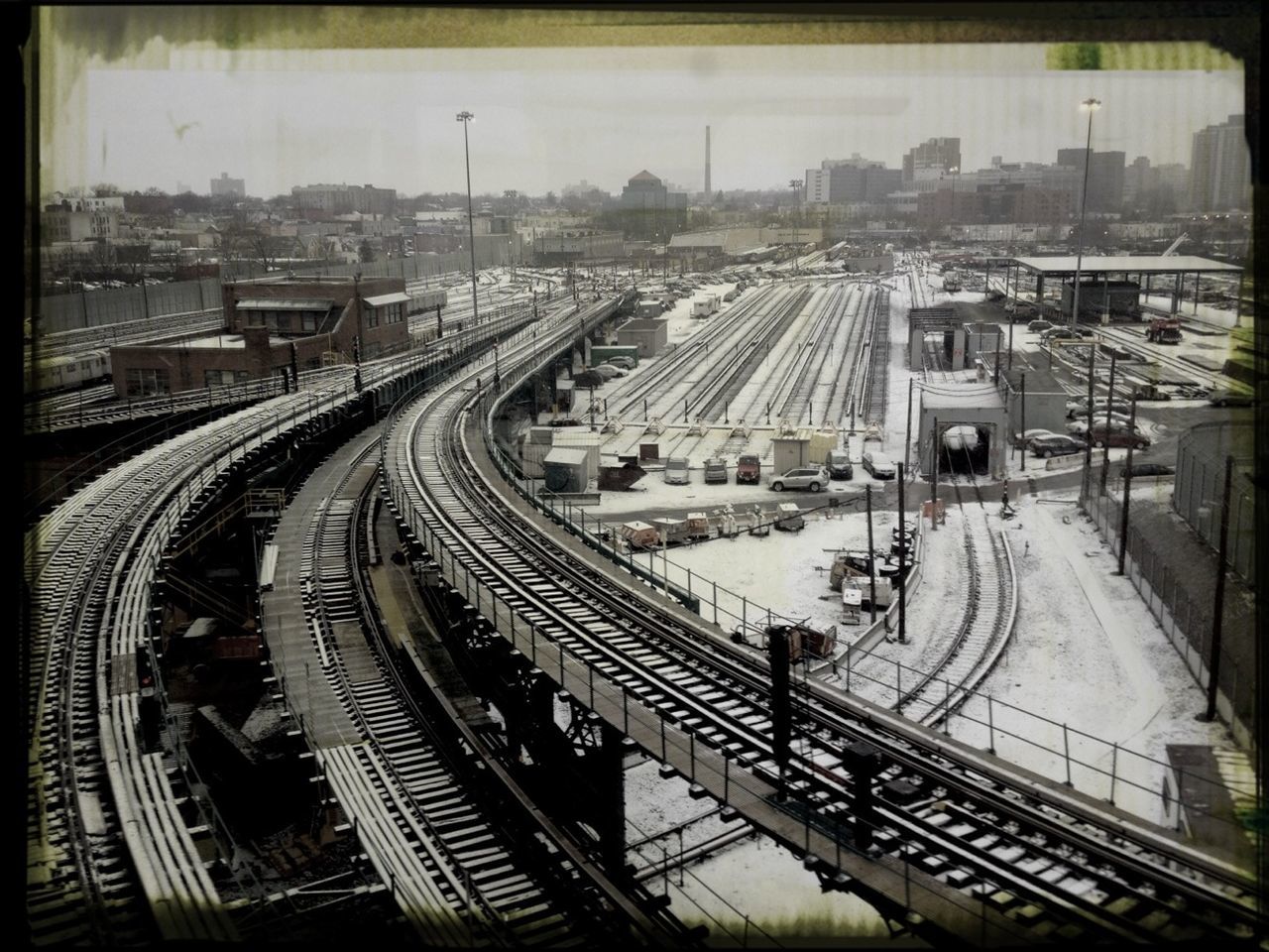 transportation, railroad track, rail transportation, public transportation, high angle view, railroad station, railroad station platform, architecture, built structure, mode of transport, city, building exterior, train - vehicle, travel, train, city life, connection, railway track, traffic, land vehicle