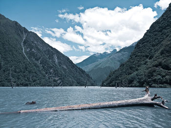 Scenic view of lake by mountains against sky